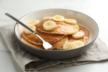 Tasty pancakes with sliced banana and honey served on table, closeup