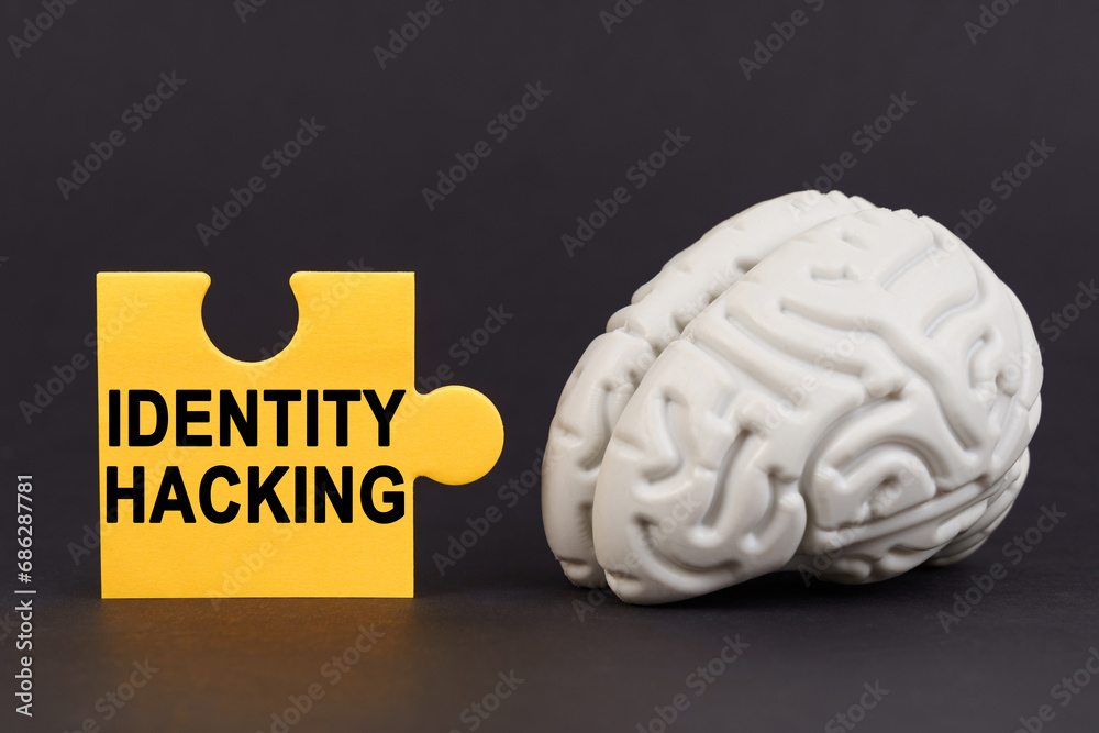 Aufkleber on a black surface there is a brain and a yellow puzzle with the inscription - identity hacking