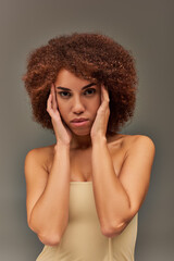 beautiful young african american woman in pastel underwear with hands near face, fashion concept