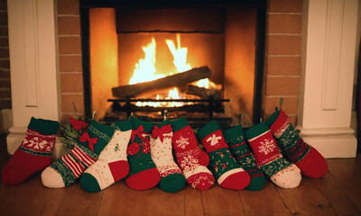 Christmas socks with gifts in front of a fireplace in a cozy home