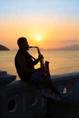 Musician playing saxophone during sunset in Santos.