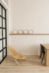 Interior is a minimalist dining room with a wooden table in Scandinavian style. Folding chair and...