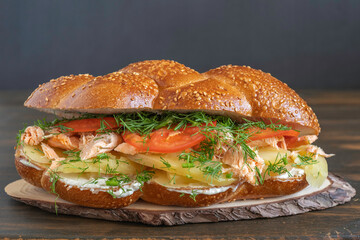 Sandwich made with challah bread, grilled salmon, boiled potato, fresh tomatoes and fennel, cream cheese.