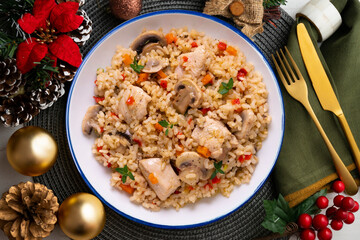 Rice paella with turkey and vegetables. Healthy recipe. Christmas food served on a table decorated with Christmas motifs.