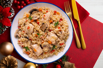 Rice paella with turkey and vegetables. Healthy recipe. Christmas food served on a table decorated with Christmas motifs.