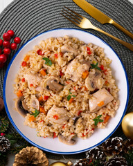 Rice paella with turkey and vegetables. Healthy recipe. Christmas food served on a table decorated with Christmas motifs.