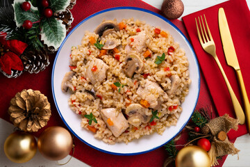 Rice paella with turkey and vegetables. Healthy recipe. Christmas food served on a table decorated with Christmas motifs.
