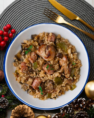 Rice paella with rabbit, sausages and green beans. Tapa traditional recipe in Valencia, Spain. Christmas food served on a table decorated with Christmas motifs.