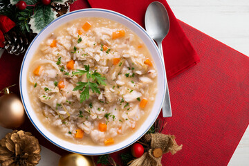 Soupy rice with artichokes and carrots. Typical Spanish gastronomy dish.  Christmas food served on a table decorated with Christmas motifs.