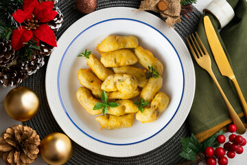 Breaded artichokes cover. Typical Spanish vegan tapas. Christmas food served on a table decorated with Christmas motifs.