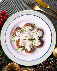 Pork meatballs with Greek tzatziki sauce with cucumber and yogurt. Christmas food on a table with decorations.
