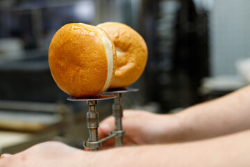 A baker fills Hanukkah donuts with jam using a special device