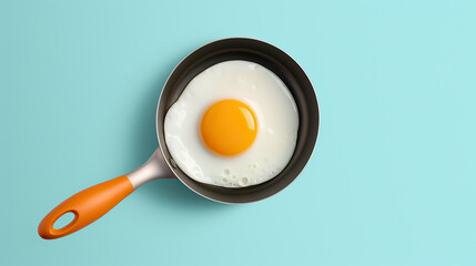 Fried egg on small pan isolated on turquoise background. - obrazy, fototapety, plakaty