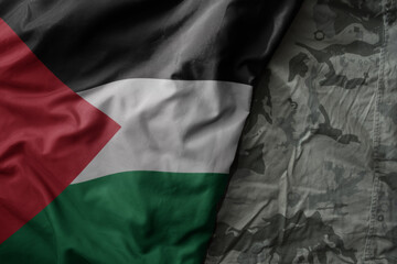 waving flag of palestine on the old khaki texture background. military concept.