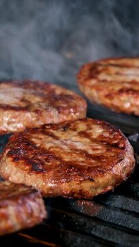 barbecue for a hamburger cooked on an open fire and turned over meat patties ground minced meat ready fried and very tasty turn over with a spatula on fire. the fire just burns and is very tasty