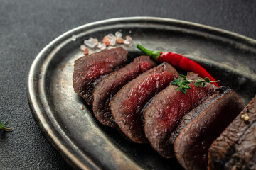 Grilled sliced skirt beef meat steak on a dark background. top view. copy space for text