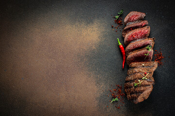 Juicy steak medium rare beef on a dark background. top view. copy space for text - obrazy, fototapety, plakaty