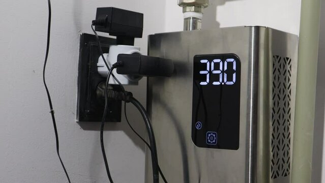 A boiler with a thermometer and a display with numbers that decrease as the temperature decreases.
