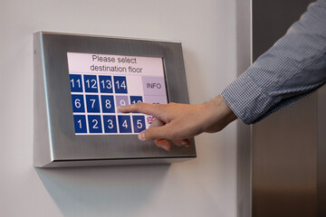 
Male hand pressing lift buttons in business centre - obrazy, fototapety, plakaty