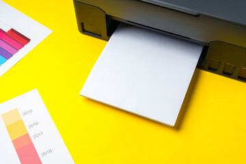 Modern printer with paper on yellow background