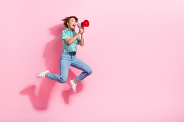 Full size profile photo of impressed sporty girl jump communicate loudspeaker empty space ad isolated on pink color background