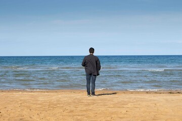 Homme regardant à l'horizon sur les plages du débarquement d'Omaha Beach