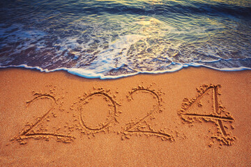 2024 on the beach sand and splashing sea wave on the shore as nature seasonal background