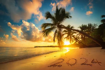Zelfklevend Fotobehang Happy New Year 2024 concept lettering on the beach sand of exotic caribbean island, beautiful sea sunrise with palm trees © ValentinValkov