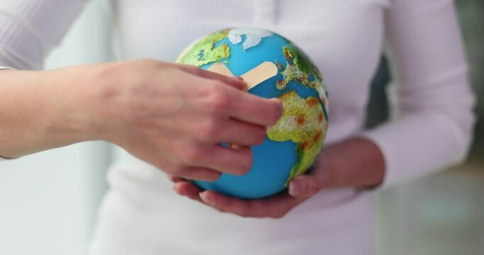 Hand holding globe and adhesive patch