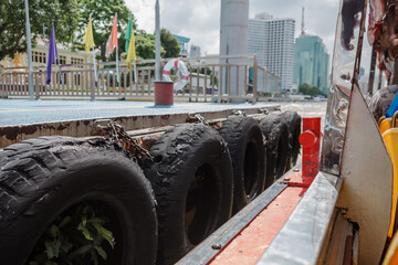 Urban Waterway: A Moored Boat at a City Dock with Protective Tires Chao Phraya river in Bangkok,...