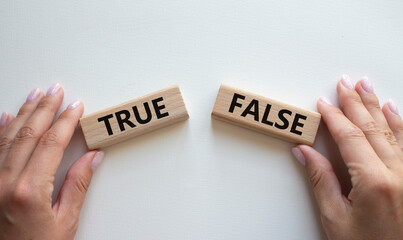 True or False symbol. Concept word True or False on wooden blocks. Businessman hand. Beautiful...