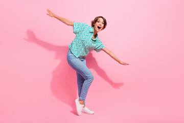 Full body photo of astonished cheerful lady arms wings flying empty space ad isolated on pink color...