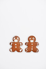 The hand-made eatable gingerbread little men with face masks on white background - 686334162