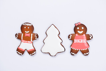 The hand-made eatable gingerbread little men and New Year Tree on white background - 686334166
