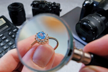 jeweler looking at ring with blue stone tourmaline paraiba, jewerly inspect and verify, pawnshop...
