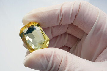 gemologist or gemstones dealer evaluating a big yellow pure gemstone. Pawnshop concept