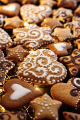 Gingerbreads in the shape of hearts and stars decorated with white icing, focus on the gingerbread heart inside.
Traditional Christmas  gingerbread cookies.