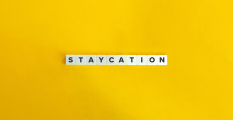 Staycation Word. Letter Tiles on Yellow Background. Minimalist Aesthetics.
