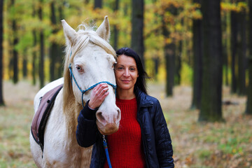 A pretty young woman and a white horse they make a nice couple