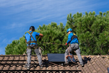 Technicians installing solar panels in a house