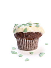 gingerbread cupcake with frosting and green christmas tree shaped sprinkles isolated on white