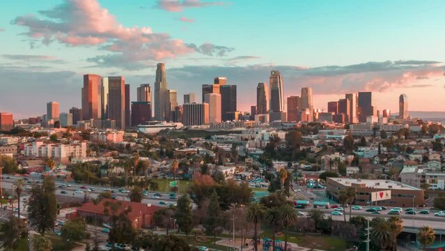 Aerial time lapse in motion or hyperlapse over Echo Park of downtown Los Angeles, California skyline and skyscrapers from above on a sunny day during golden hour before sunset.