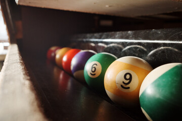 Selective focus at pool billiards ball on the cabinet side of pool billiard table. 