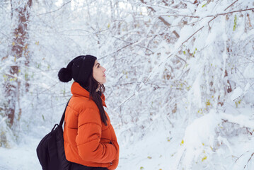 Relaxed woman breathing fresh air in a snowy forest. Winter time