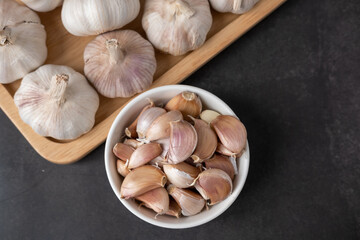 Big and small heads of garlic on a black background.