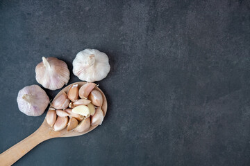 Big and small heads of garlic on a black background.