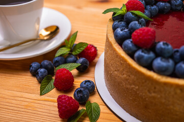 close-up of cheesecake with cream filling, decorated with fresh berries, blueberries and raspberries, festive New Year's cake, Christmas	