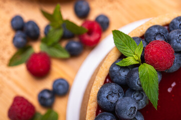 close-up of cheesecake with cream filling, decorated with fresh berries, blueberries and raspberries, festive New Year's cake, Christmas	