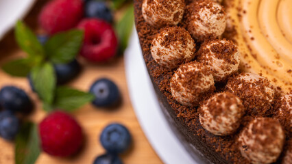 close-up of cheesecake with cream filling, decorated with fresh berries, blueberries and raspberries, festive New Year's cake, Christmas	