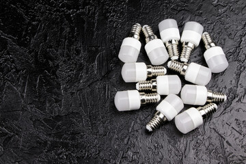 Electric LED lamps on a black graphite background. LED light bulbs on a stone background.